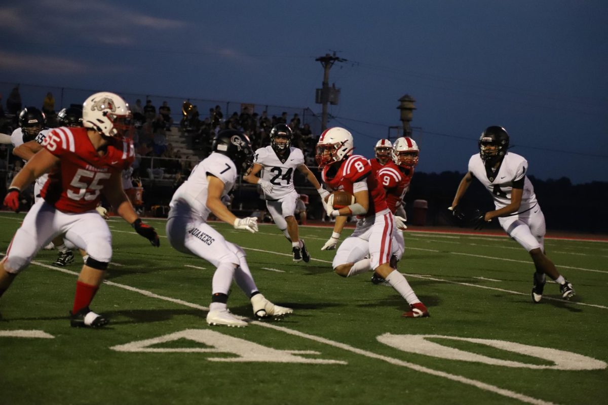 Making moves: Dekota Roberts (12) runs past the 40-yard line carrying the ball during the Aug. 23 game against Quaker Valley. Roberts was selected to be one of the team’s four captains.