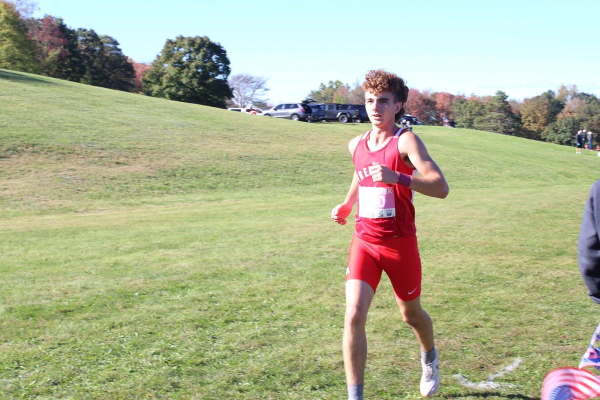 Conquering the course:  Running in the MAC invitational on Oct. 10 Noah Chaousy (11) maintains form to help reduce his time. Form is an important aspect of Cross Country as it will affect runner’s times and scores.  