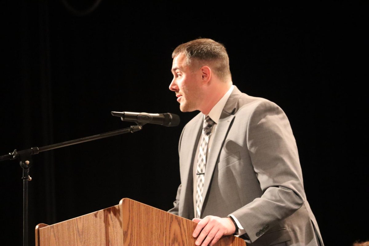 Speaking clearly: Addressing the audience, Mr. Steven Mott, the high school principal and moderator of the NHS, explains how each student inducted into the NHS plays an extremely important role in their community. Students were recognized for the ways they benefited their community and school during the speech.