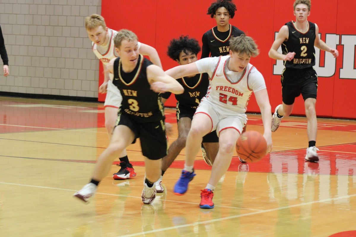 Back on the court:  Dribbling away from defenders, Adam Rhoades (12), runs the ball down the court. As one of four seniors on the roster, Rhoades hopes to make a bigger impact for the Bulldogs this season.