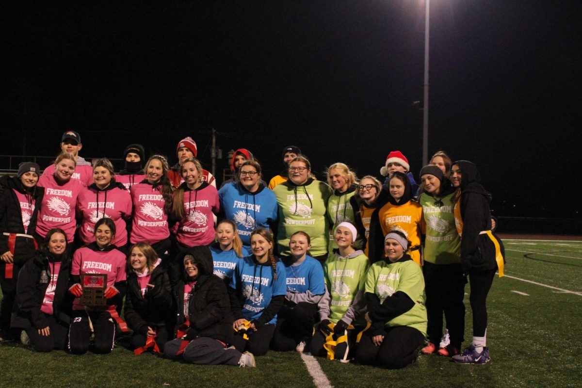 Circle of smiles: Coming together after the game, every participant huddles around for a photo. Participating in Powderpuff is an opportunity for students from all grade levels to come together and play against one another in friendly competition.
