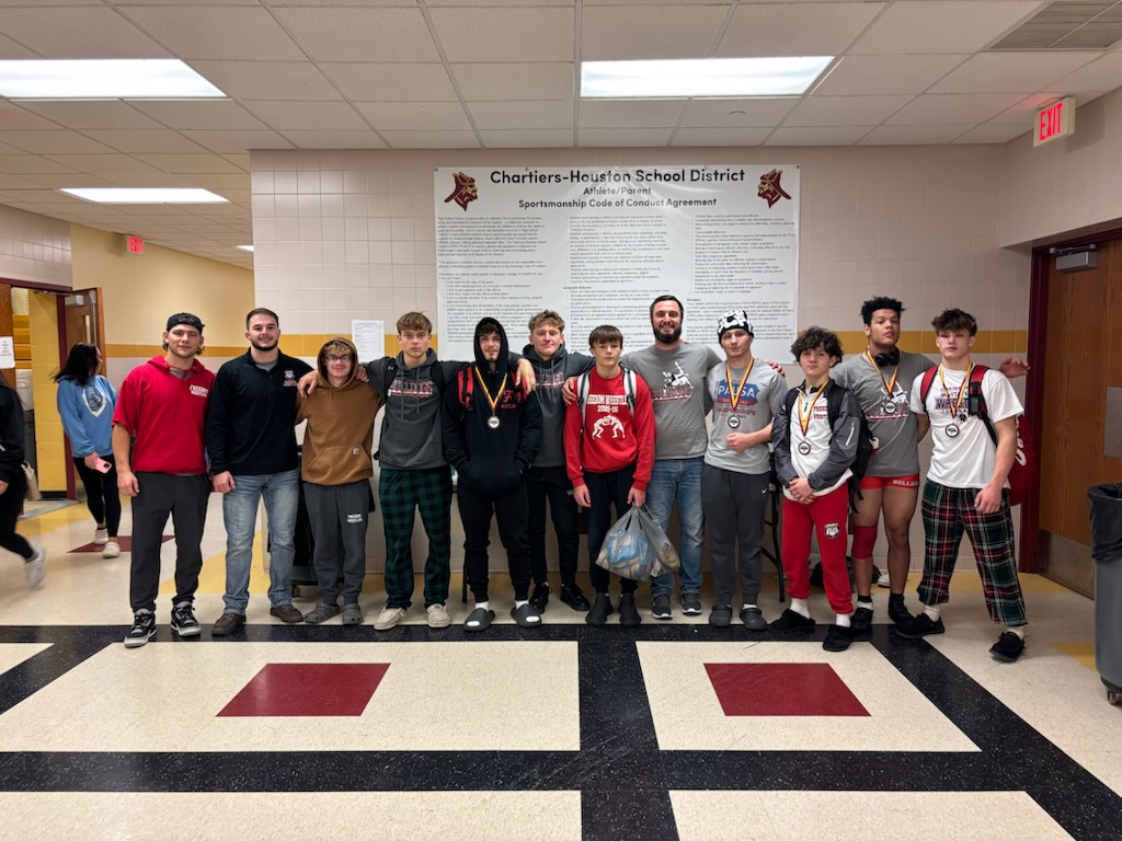 Strong start:  Posing for a group picture, the wrestling team smiles after their performance in the Chartier-Houston tournament. The tournament was one of the first ways during the season for the team to test their abilities.