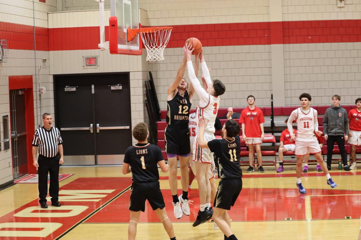 Leaping into the air, William Kumrow (10) attempts to get the rebound off of the defender. Rebound the ball after a shot allows for the team to regain possession of the ball so they can score more points.
