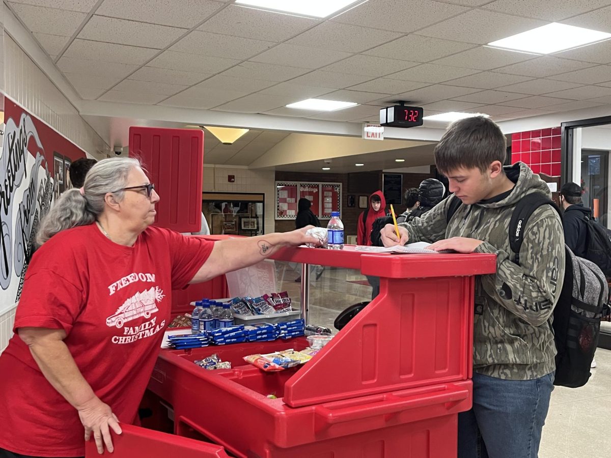 Morning meals: Standing at the breakfast cart, Ms. Becky Spieler collects Lucas Bradel’s (10) prefered breakfast items. A free breakfast is provided for all students through either the breakfast cart or within the cafeteria.