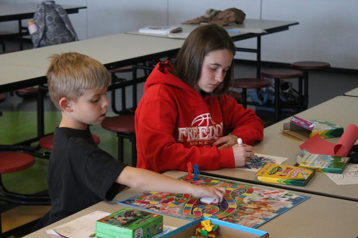 Best buddies: Spending quality time with her mentee, Payton Bickerstaff (12) colors, while her mentee sets up Candy Land. A major part of Big Brothers Big Sisters is for children to have a mentor that they are able to spend time with and look up to. 